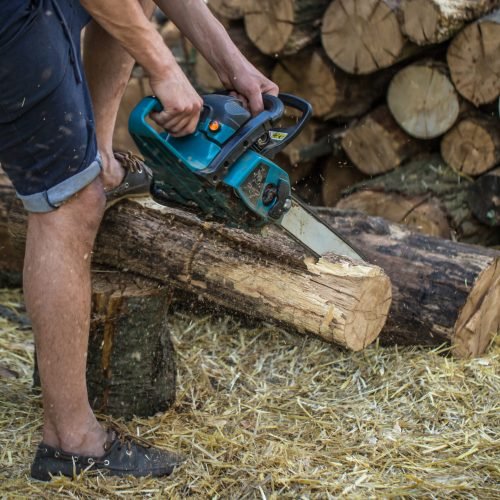 Man chopping wood with a chainsaw ,close-up