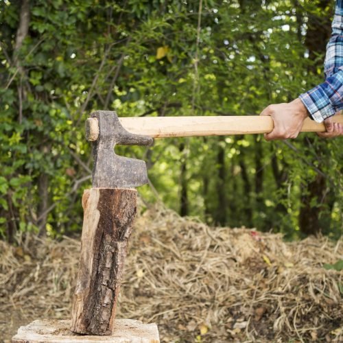 side-view-man-using-axe-chop-wood